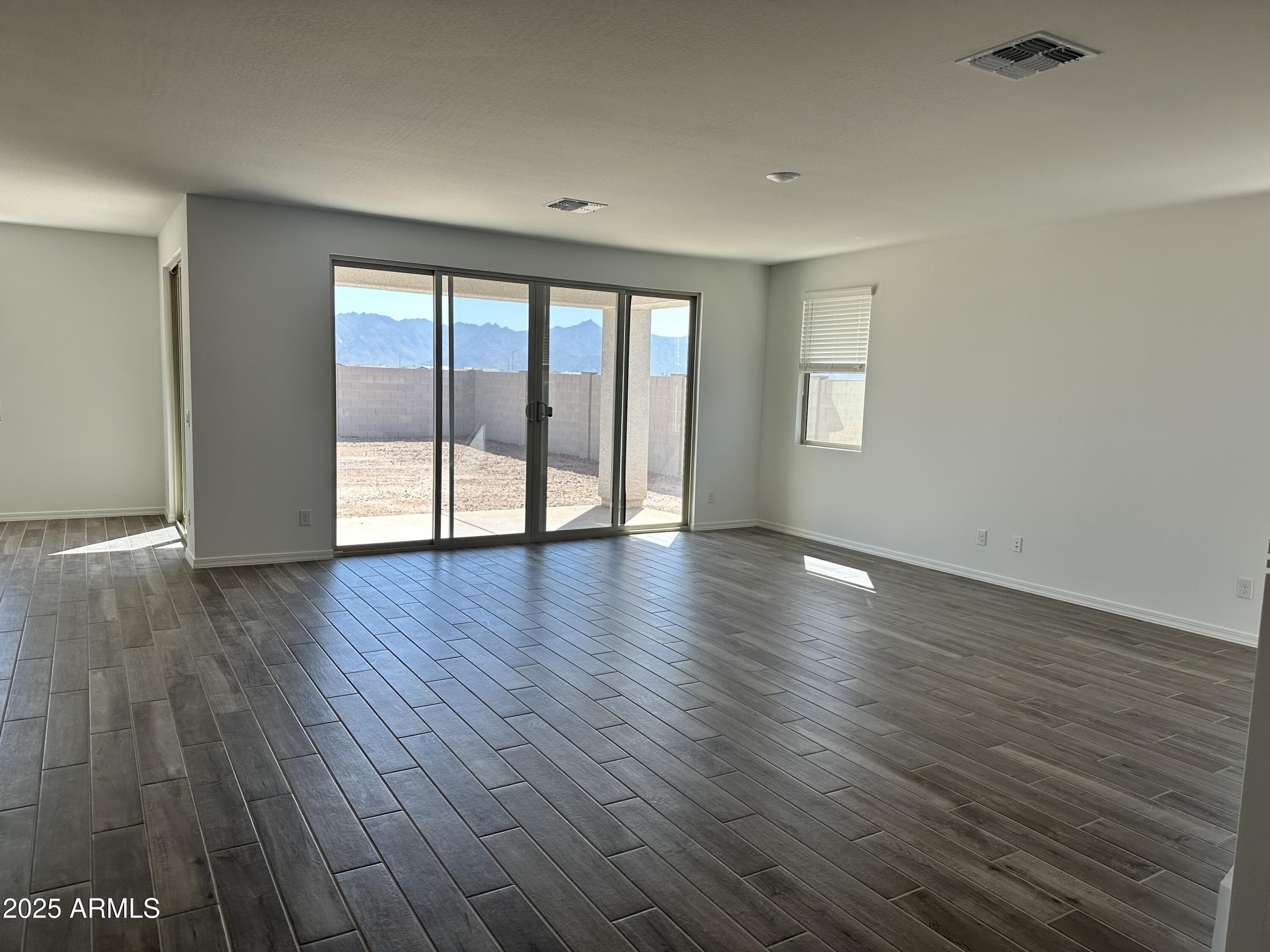 5535 West Hopi Trail Laveen, AZ 85339 - Photo 6 of 45 a view of an empty room with wooden floor and a window