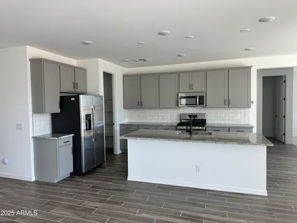 a kitchen with stainless steel appliances granite countertop a refrigerator and a stove top oven