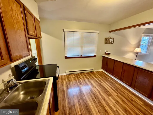 a kitchen with a refrigerator stove and wooden floor