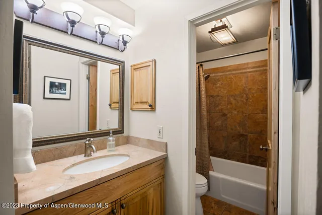 a bathroom with a granite countertop sink toilet and shower