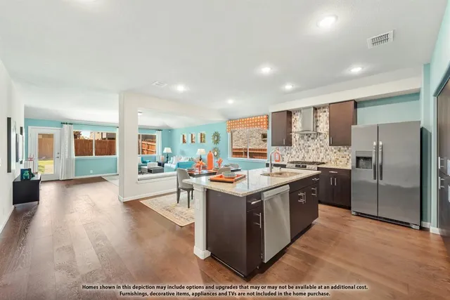 a kitchen with stainless steel appliances kitchen island granite countertop a stove and a refrigerator