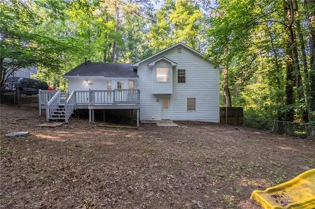a view of a house with a small yard and a large tree