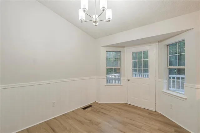 an empty room with windows and ceiling fan