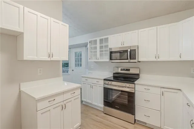 a kitchen with white cabinets stainless steel appliances and sink