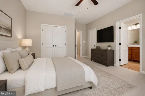 a spacious bedroom with a bed and a flat screen tv