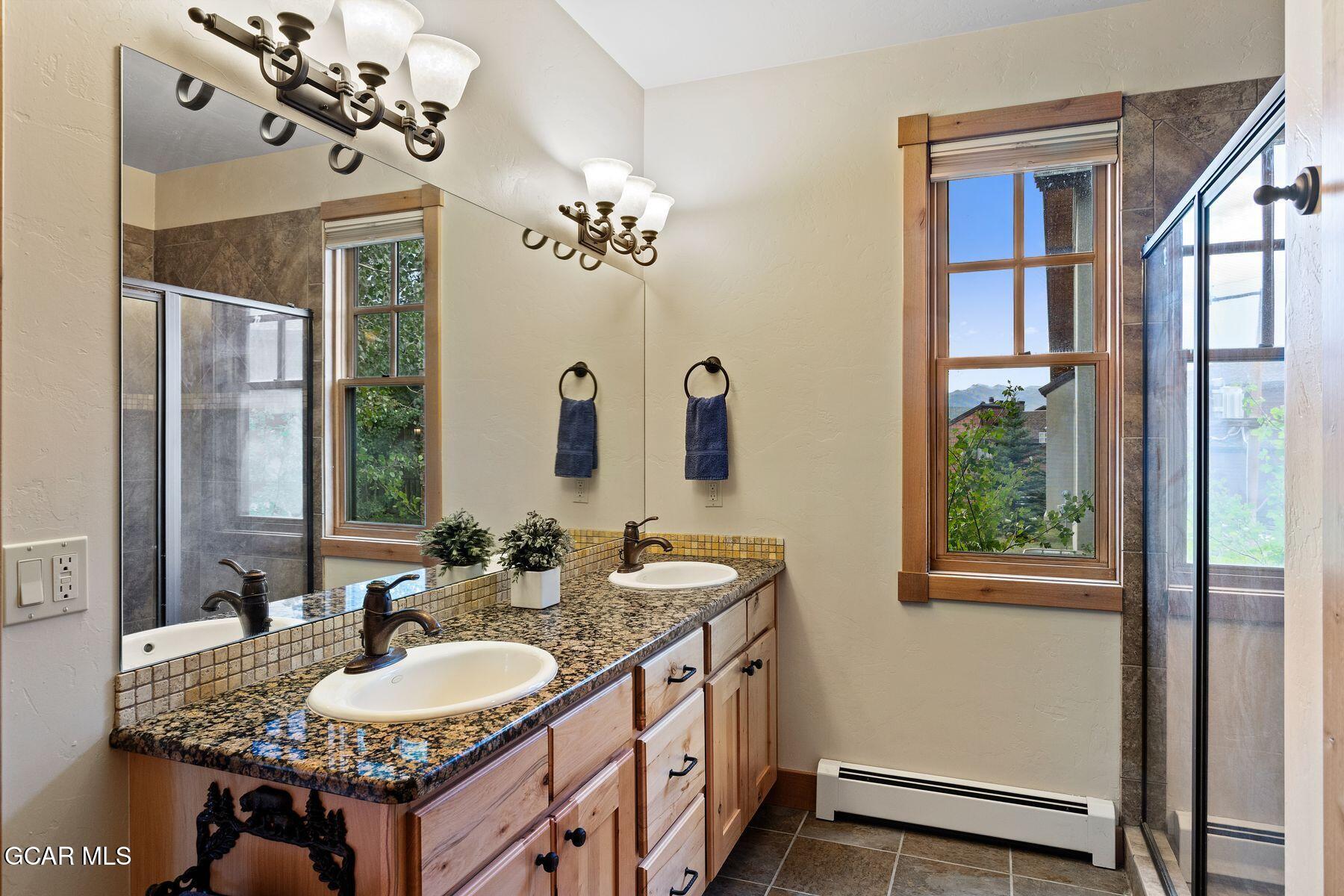 445 Trappers Way Fraser, CO 80442 - Photo 19 of 37 a bathroom with a granite countertop sink and a mirror