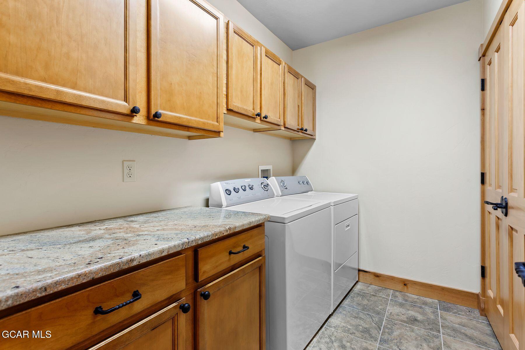 445 Trappers Way Fraser, CO 80442 - Photo 34 of 37 a utility room with granite countertop cabinets washer and dryer