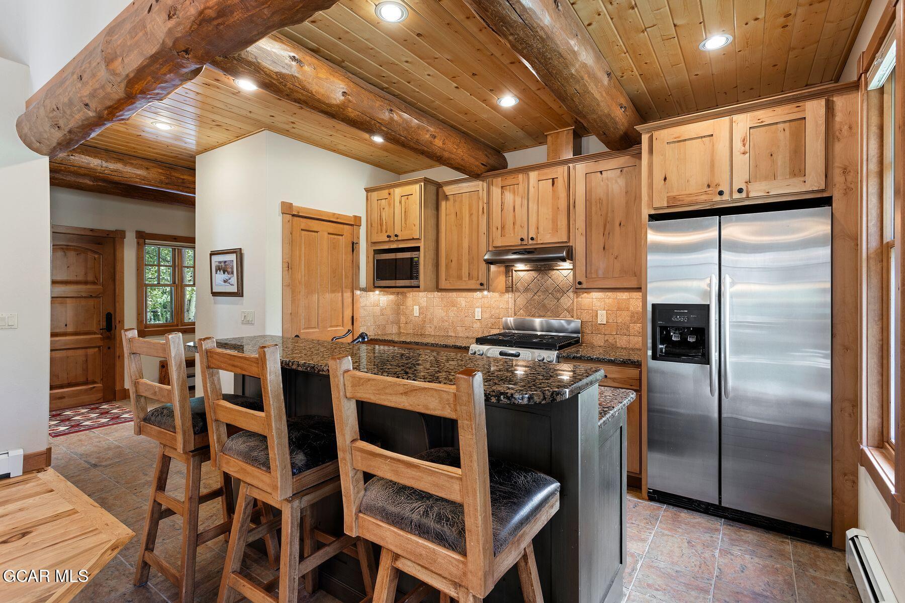 445 Trappers Way Fraser, CO 80442 - Photo 6 of 37 a kitchen with kitchen island a counter top space cabinets and stainless steel appliances