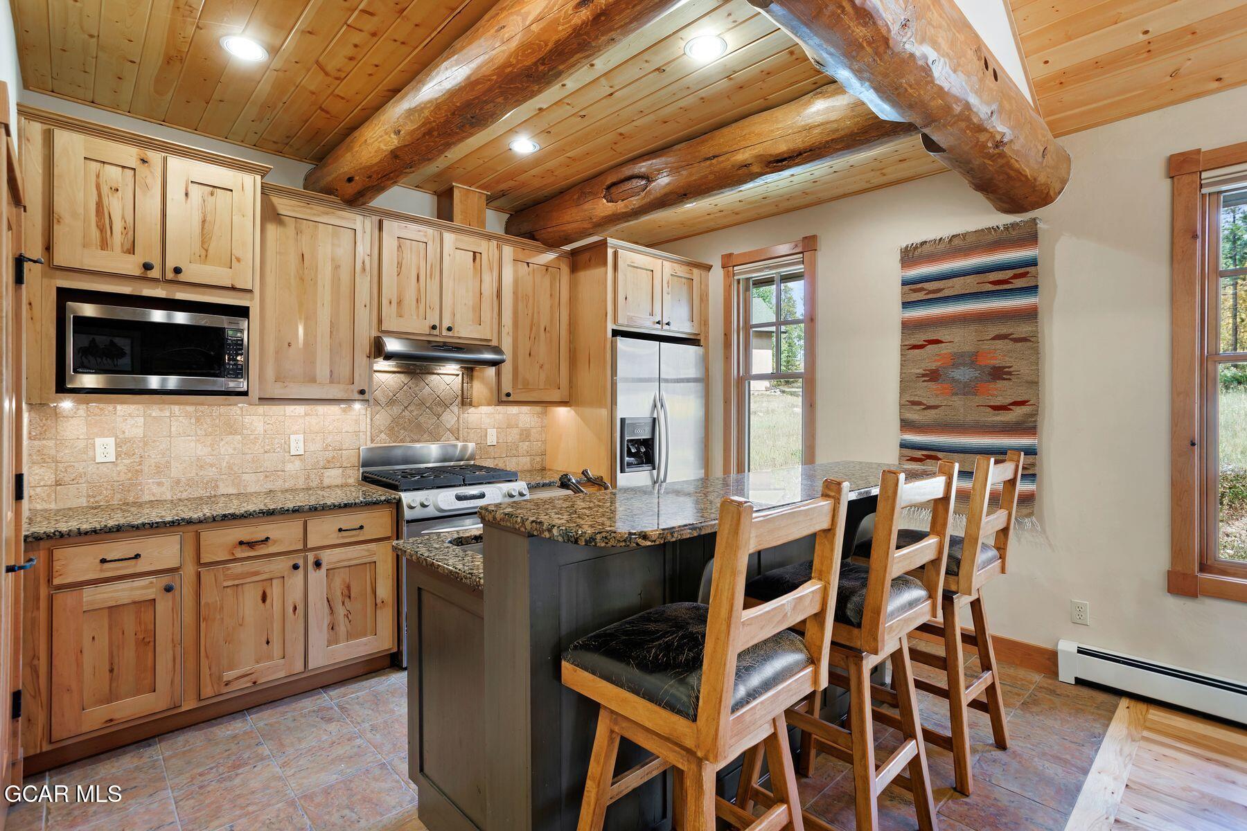 445 Trappers Way Fraser, CO 80442 - Photo 7 of 37 a kitchen with stainless steel appliances granite countertop a stove a sink dishwasher and a microwave