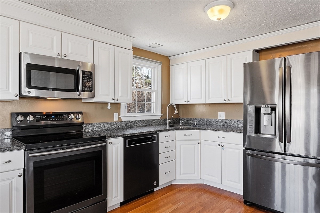 163 Mills Avenue Revere, MA 02151 - Photo 20 of 22 a kitchen with granite countertop a refrigerator stove and microwave