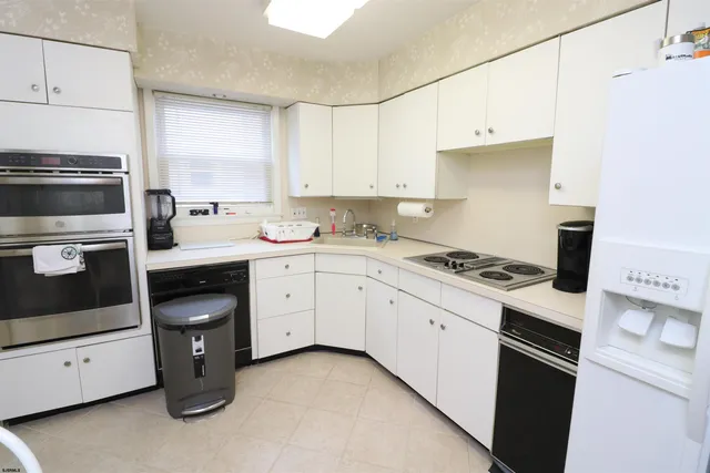 a kitchen with a sink a stove a refrigerator and cabinets