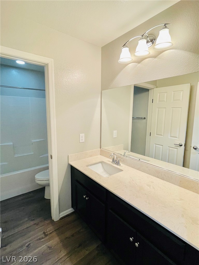 9921 Sable Point Street Las Vegas, NV 89178 - Photo 32 of 43 Rich wood-look flooring and dark cabinetry anchor this well-appointed bath space.