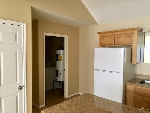 a bedroom with a bed and a refrigerator