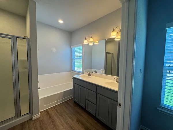 a bathroom with a tub sink and mirror