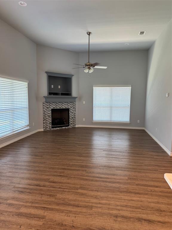 792 East Northside Drive Pilot Point, TX 76258 - Photo 2 of 18 an empty room with wooden floor fireplace and windows