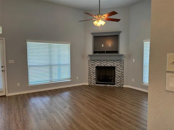 a view of a livingroom with a fireplace a chandelier and wooden floor