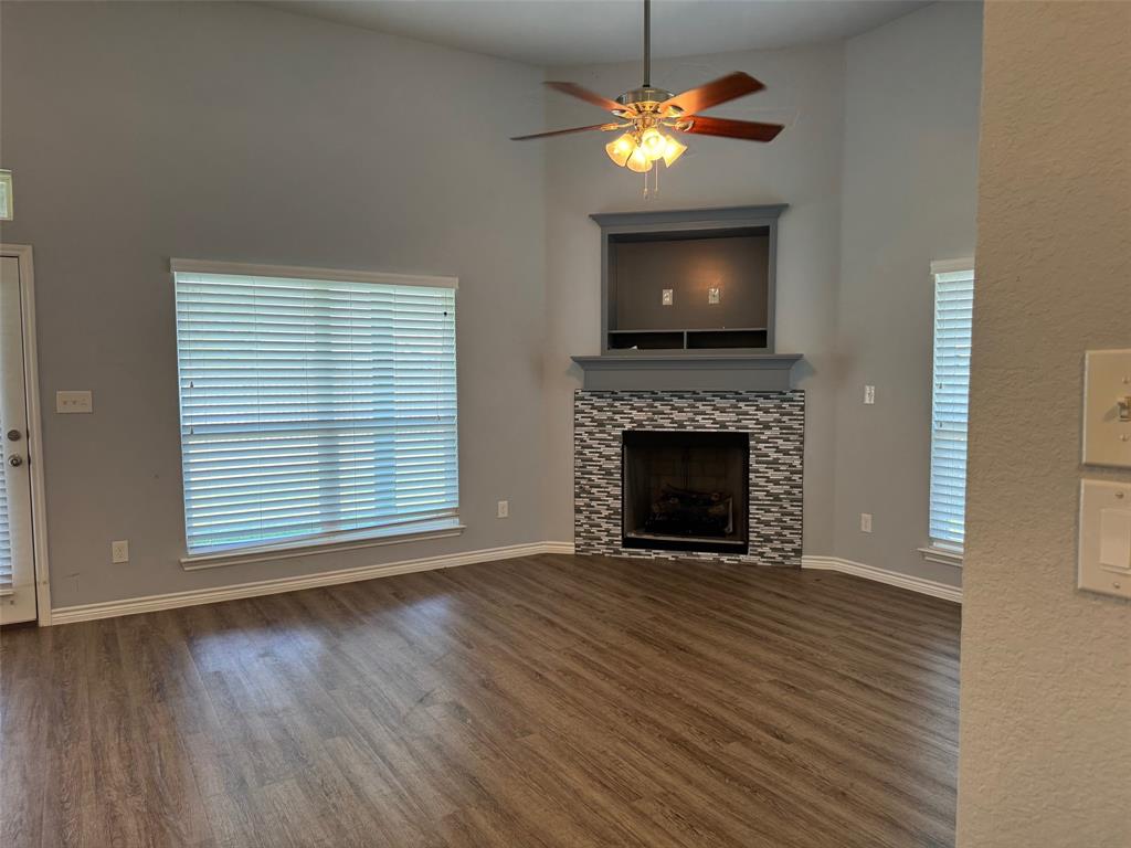 792 East Northside Drive Pilot Point, TX 76258 - Photo 4 of 18 a view of a livingroom with a fireplace a chandelier and wooden floor