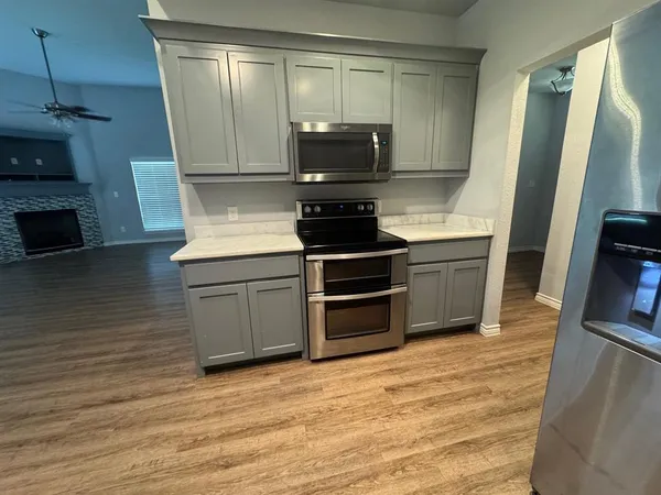 a kitchen with granite countertop a stove and a microwave