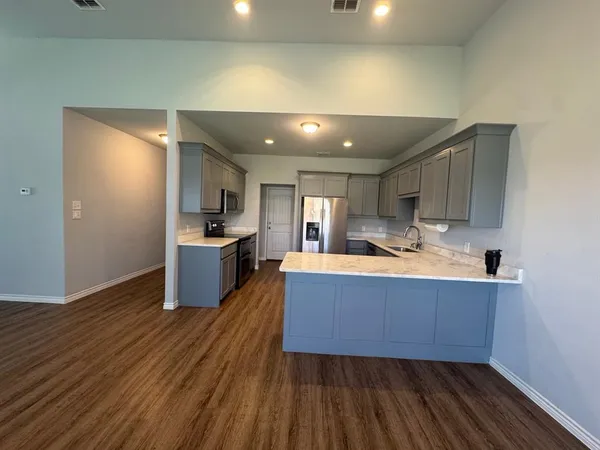 a kitchen with stainless steel appliances granite countertop a sink a stove and a refrigerator