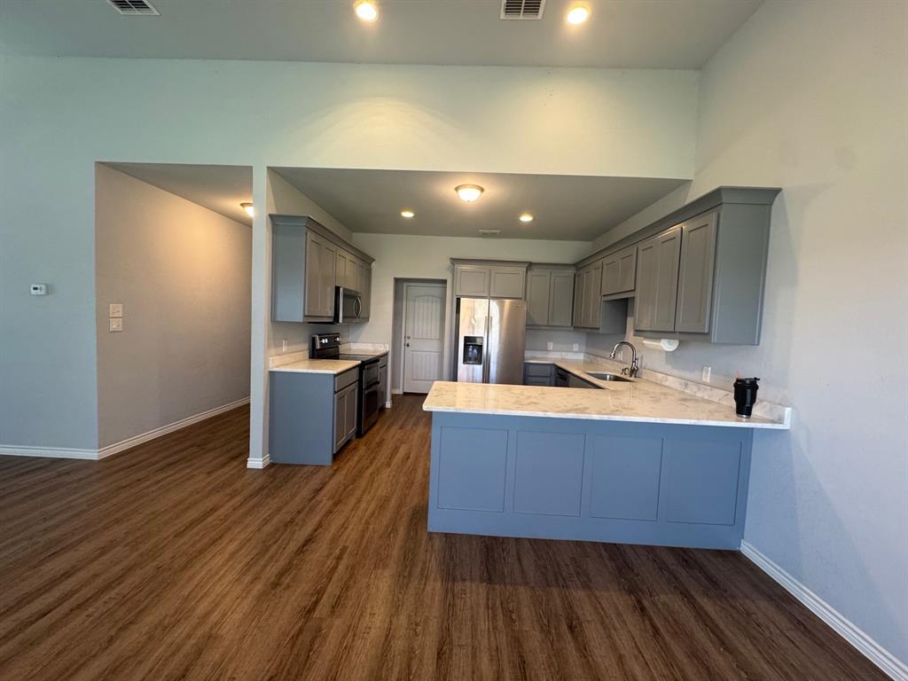 792 East Northside Drive Pilot Point, TX 76258 - Photo 8 of 18 a kitchen with stainless steel appliances granite countertop a sink a stove and a refrigerator