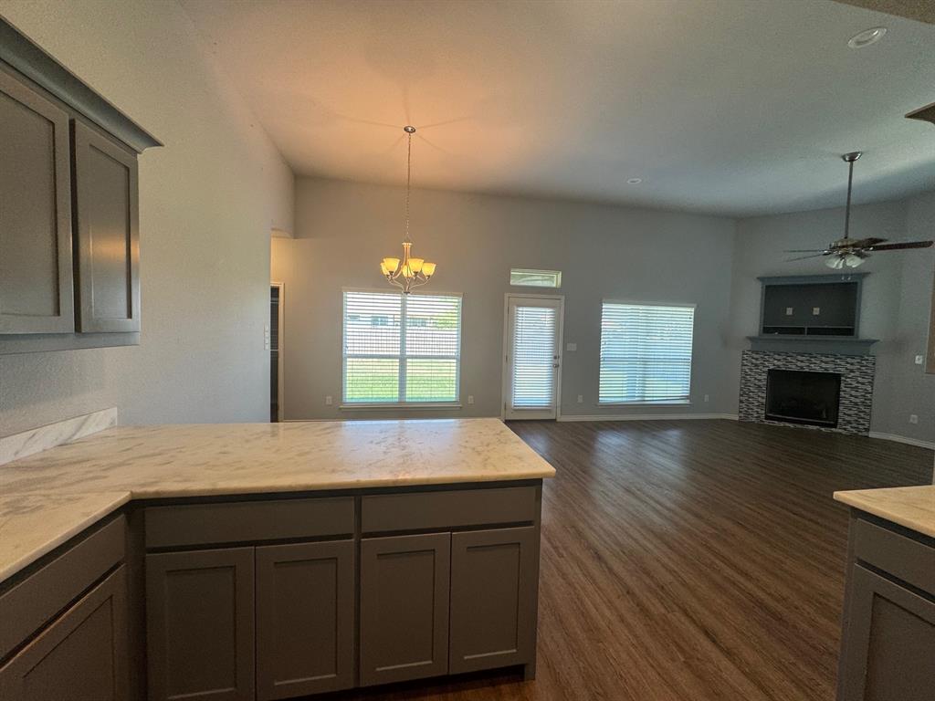 792 East Northside Drive Pilot Point, TX 76258 - Photo 9 of 18 a kitchen with a wooden floor and a fireplace
