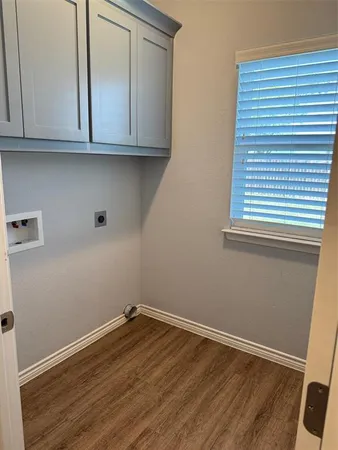 a view of a kitchen with wooden floor and cabinets