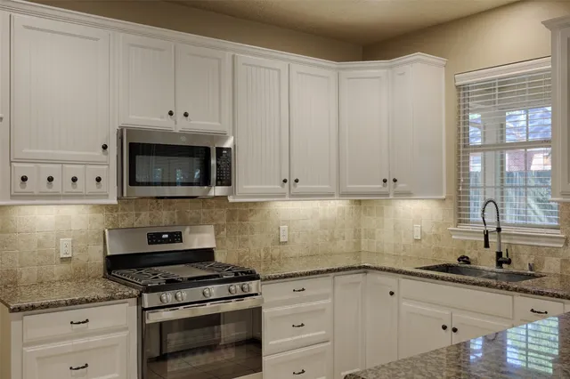 a kitchen with granite countertop a sink and cabinets