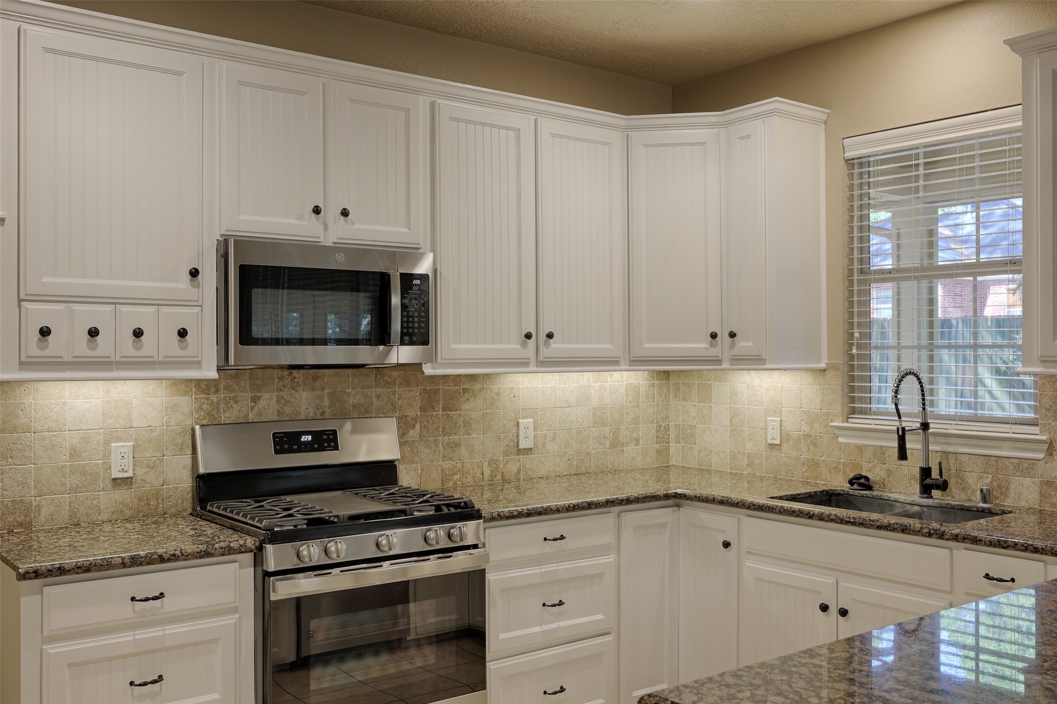 14918 Pollux Drive Willis, TX 77318 - Photo 15 of 46 a kitchen with granite countertop white cabinets and appliances