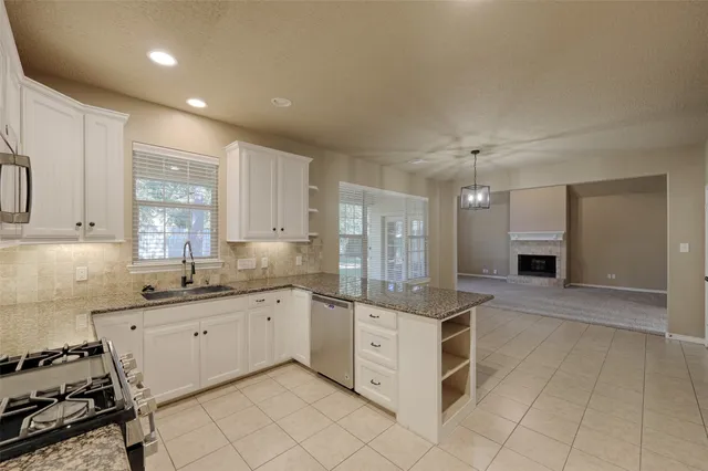 a view of a kitchen with granite countertop cabinets and chandelier