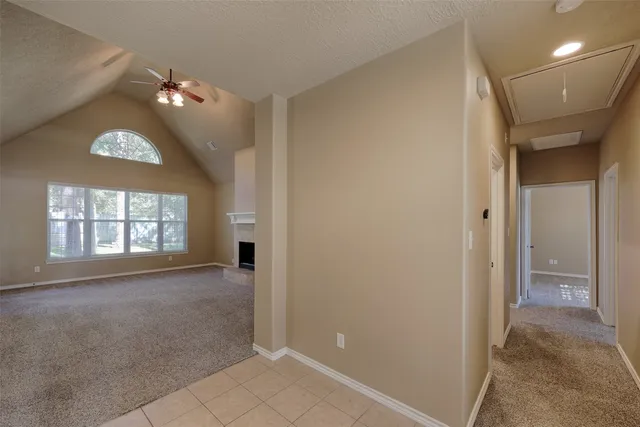 an empty room with windows and fireplace