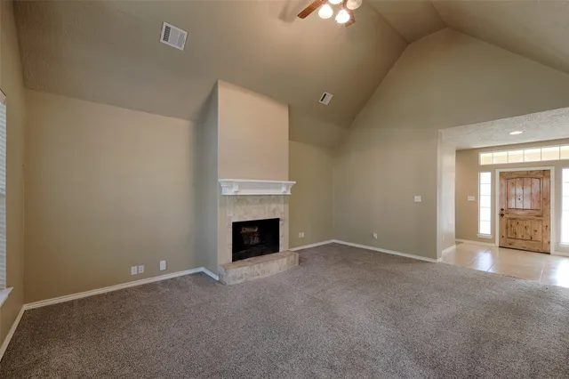 a view of a big room with windows and chandelier fan
