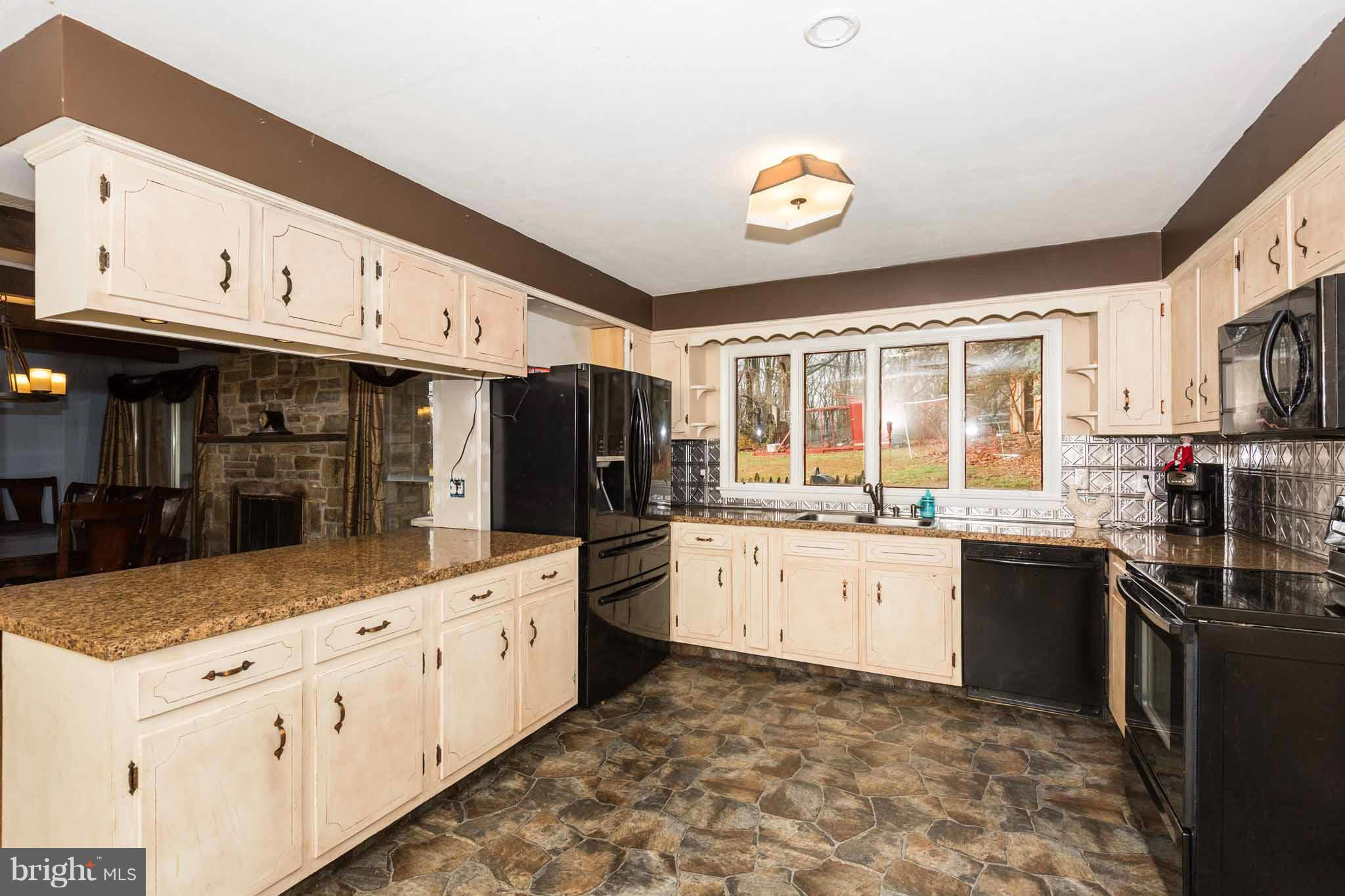 19414 Resh Mill Road Hampstead, MD 21074 - Photo 6 of 25 a kitchen with stainless steel appliances granite countertop a stove top oven a sink a counter space and cabinets