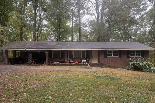 a front view of a house with yard and trees in the background