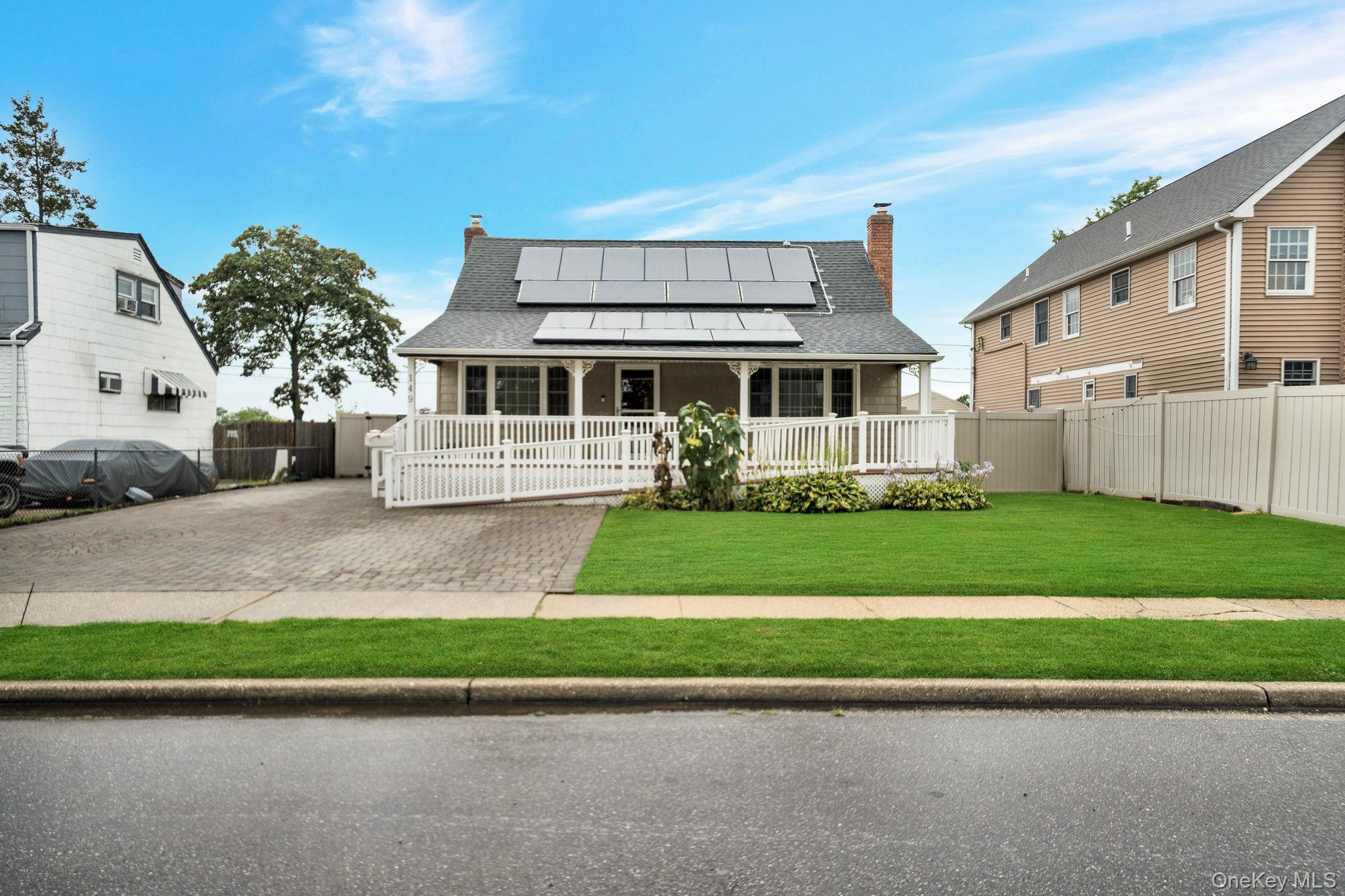 149 Cardinal Road Levittown, NY 11756 - Photo 1 of 1 Rear view of property with a chimney, solar panels, and a shingled roof