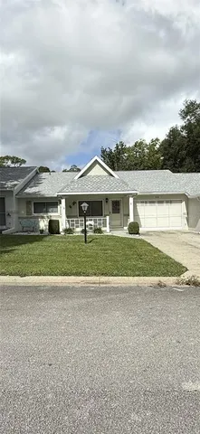 a view of house with a big yard and potted plants