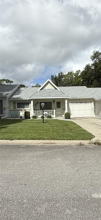a view of house with a big yard and potted plants