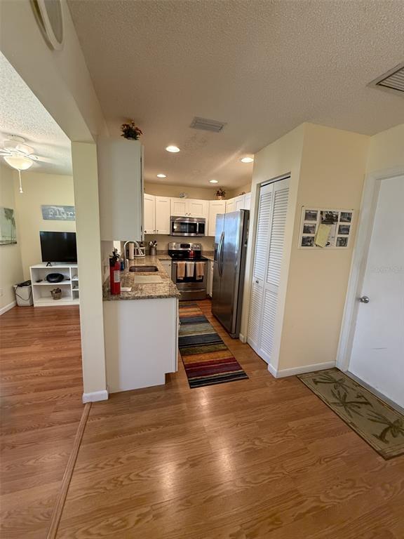 9290 Southwest 89th Terrace, Unit B Ocala, FL 34481 - Photo 6 of 20 a view of a kitchen with wooden floor and electronic appliances