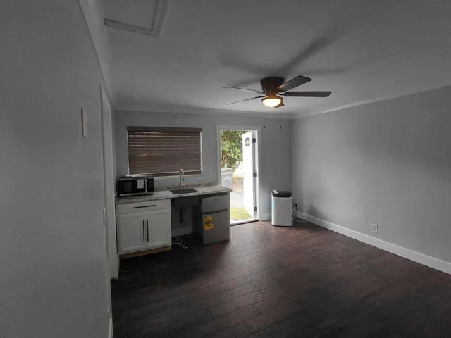 an empty room with a kitchen and sink