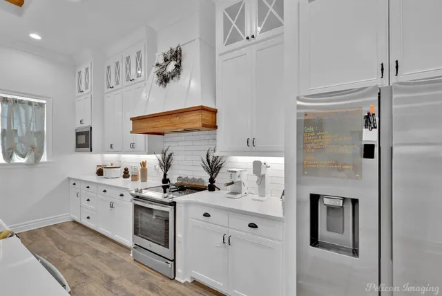 a kitchen with stainless steel appliances white cabinets and a refrigerator