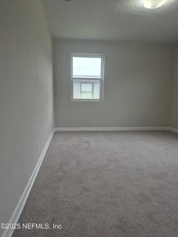 an empty room with windows and closet