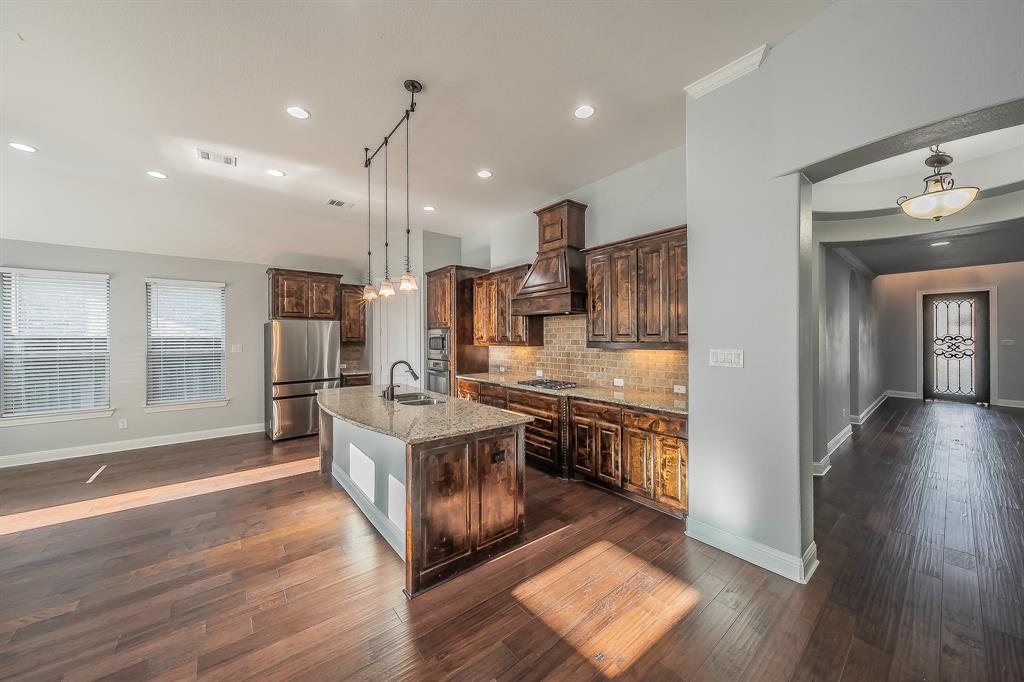 2823 Exeter Drive Trophy Club, TX 76262 - Photo 19 of 40 a large kitchen with stainless steel appliances granite countertop a stove and a wooden floors