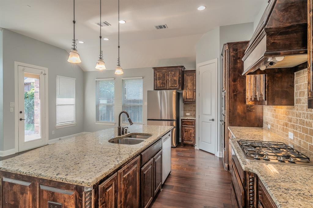 2823 Exeter Drive Trophy Club, TX 76262 - Photo 20 of 40 a kitchen with stainless steel appliances granite countertop a sink stove and refrigerator