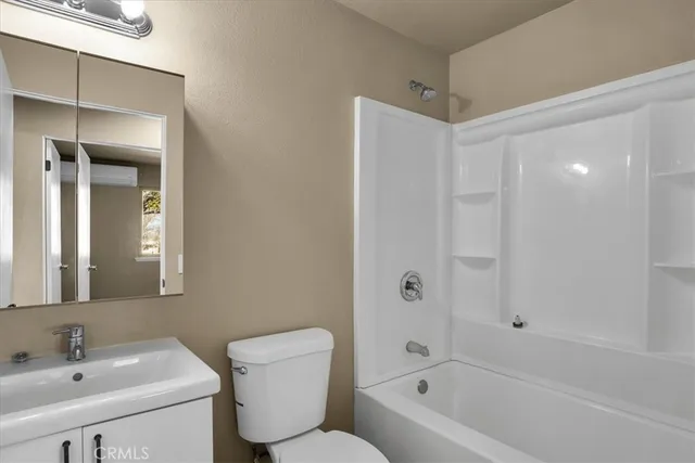 a bathroom with a bathtub shower sink vanity and toilet