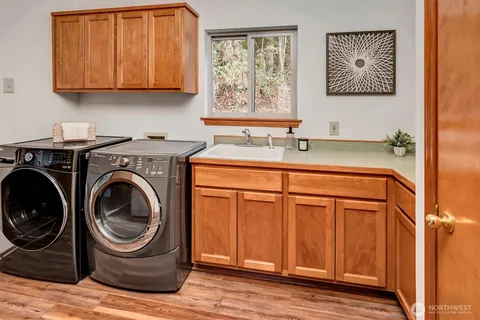 a utility room with sink dryer and washer