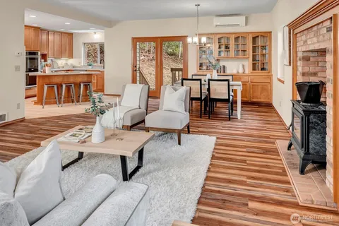 a living room with furniture a large window with kitchen view