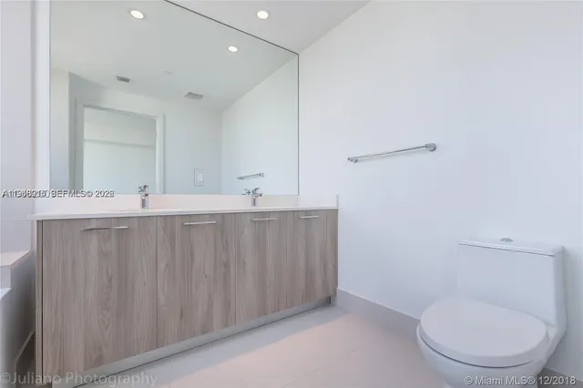 a bathroom with a toilet a sink and mirror