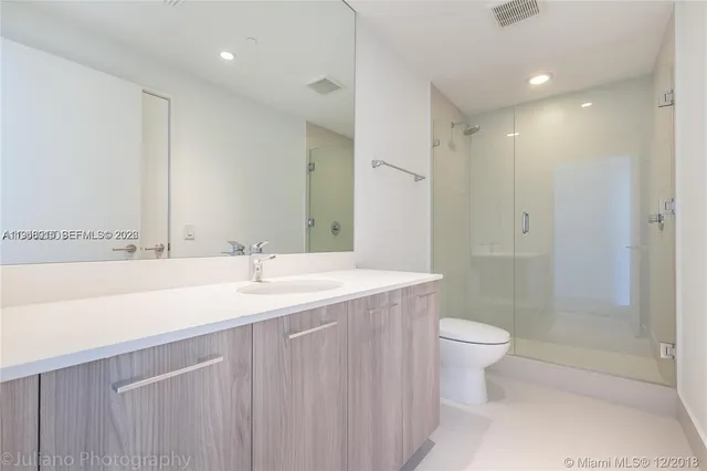 a bathroom with a double vanity sink toilet and shower