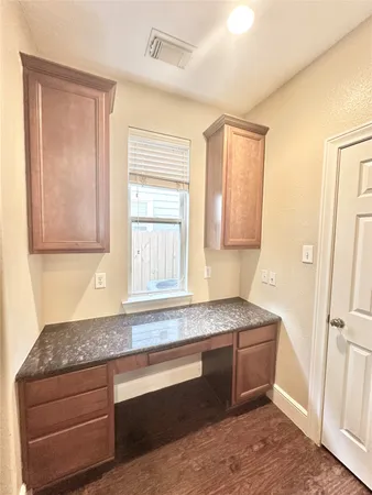 a bathroom with a granite countertop sink and mirror with bathtub