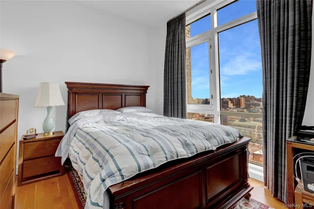 a bedroom with a bed and large windows