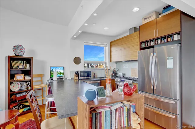 a kitchen with stainless steel appliances a refrigerator and a wooden floor